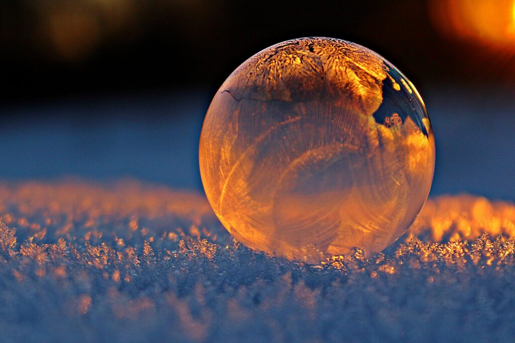 pexels photo 302743 302743 Close-up shot of a frozen bubble with warm reflections resting on a snowy surface at twilight.